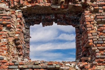 Canvas Print - hole in the red brick wall with sky and clouds