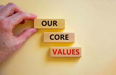 Our core values symbol. Concept words 'Our core values' on wooden blocks on a beautiful white background. Businessman hand. Business and our core values concept. Copy space.