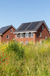 Solar panels on the roof of new built houses in The Netherlands collecting green energy from the sun in a modern and sustainable way. New technology on Dutch houses concept, surrounded by nature 