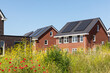 Solar panels on the roof of new built houses in The Netherlands collecting green energy from the sun in a modern and sustainable way. New technology on Dutch houses surrounded by nature