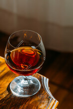 Cognac Glass On Wooden Table With Natural Light