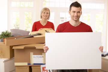 Poster - Smiling couple surrounded with boxes in new house