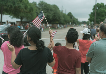 Filtered image diverse people waving American flag on Independence Day Street Parade Celebration