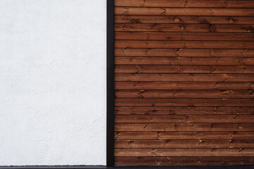 The combination on the wall two different textures - brown wood planks and a white decorative plaster