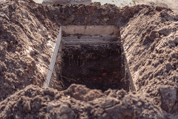 Freshly dug grave pit at cemetery, a close-up.