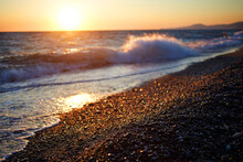 Beautiful Orange Sea Sunset. Waves On A Pebble Beach. Blurred Background