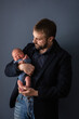 Dad holds a crying newborn in his arms. Happy childhood, selective focus.