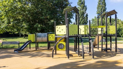 empty children playground with slide and climbing bars activities in public green park modern