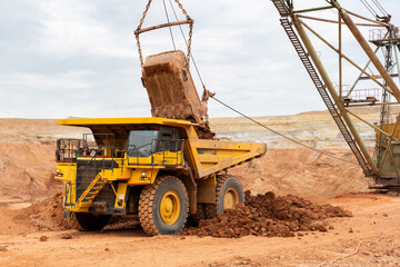 Wall Mural - large excavator loads rock with iron or bauxite mining