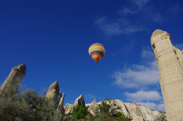 Love Valley, a colorful hot air balloon flies in the blue sky, Cappadocia, Turkey