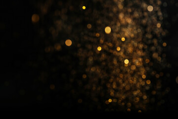 Wall Mural - blurred view of golden lights on black background. bokeh effect