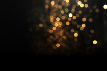 Wall Mural - blurred view of golden lights on black background. bokeh effect