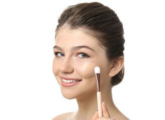 Wall Mural - Beautiful girl applying foundation with brush on white background. Face contouring