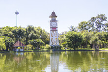 Remote Photo Clock Tower In The Park With Tree Greenery There Is A Pond In Front And A Sky With Clouds In The Background. Famous Became The Symbol Of Park Thailand