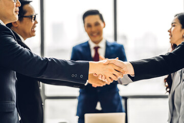 Image two business partners in elegant suit successful handshake together in front of group of casual business clapping hands in modern office.Partnership approval and thanks gesture concept