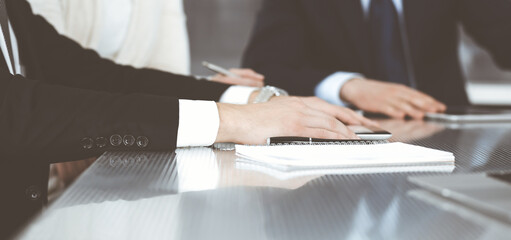 Business people working together at meeting in a modern office. Unknown businessman and woman with colleagues or lawyers at negotiation about contract