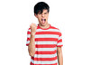 © Krakenimages.com - Handsome hipster young man wearing casual striped t shirt angry and mad raising fist frustrated and furious while shouting with anger. rage and aggressive concept.