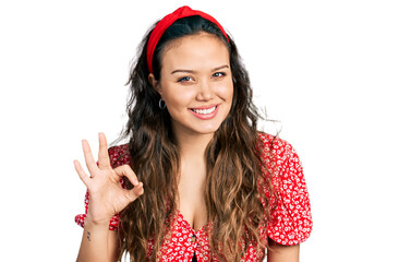 Young hispanic girl wearing casual clothes smiling positive doing ok sign with hand and fingers. successful expression.