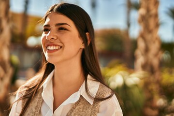 Young hispanic woman smiling happy standing at the city.