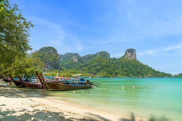 Wall Mural - railay beach east with exotic limestone mountain and longtail wooden tourist boat, krabi, thailand