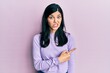© Krakenimages.com - Young hispanic woman wearing casual clothes pointing aside worried and nervous with forefinger, concerned and surprised expression