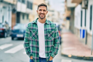 Young caucasian man smiling happy standing at the city.