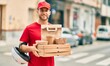 © Krakenimages.com - Young caucasian deliveryman smiling happy holding delivery food at the city.