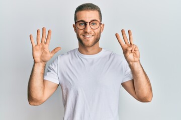 Wall Mural - Young caucasian man wearing casual clothes and glasses showing and pointing up with fingers number eight while smiling confident and happy.