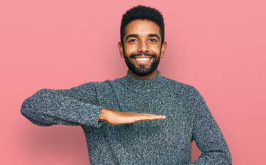 Canvas Print - Young african american man wearing casual clothes gesturing with hands showing big and large size sign, measure symbol. smiling looking at the camera. measuring concept.