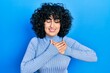 © Krakenimages.com - Young middle east woman wearing casual clothes smiling with hands on chest, eyes closed with grateful gesture on face. health concept.