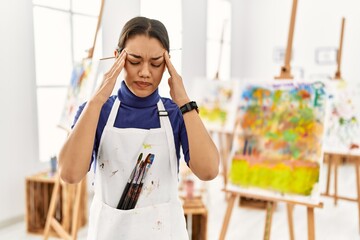 Sticker - Young brunette woman at art studio with hand on head, headache because stress. suffering migraine.