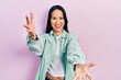 © Krakenimages.com - Beautiful hispanic woman with nose piercing wearing casual green jacket looking at the camera smiling with open arms for hug. cheerful expression embracing happiness.