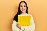 Fototapeta  - Beautiful hispanic woman with nose piercing holding book smiling with a happy and cool smile on face. showing teeth.