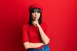 © Krakenimages.com - Young hispanic woman wearing french look with beret asking to be quiet with finger on lips. silence and secret concept.