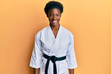 Poster - Young african american girl wearing karate kimono and black belt with a happy and cool smile on face. lucky person.