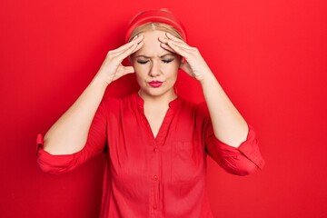 Canvas Print - Young blonde woman wearing casual red shirt suffering from headache desperate and stressed because pain and migraine. hands on head.