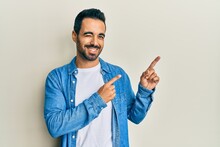 Young Hispanic Man Pointing With Fingers To Himself Winking Looking At The Camera With Sexy Expression, Cheerful And Happy Face.