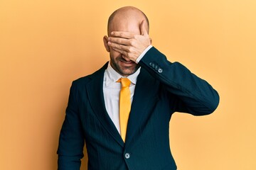 Sticker - Young hispanic man wearing business suit and tie smiling and laughing with hand on face covering eyes for surprise. blind concept.