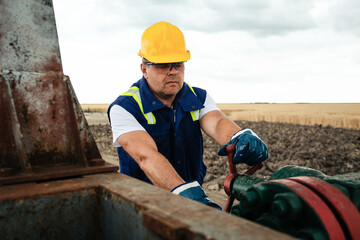 Wall Mural - Oil worker is turning valve on the oil pipeline. Oil and Gas Industry. 