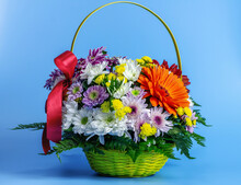 Bright Festive Bouquet In A Basket On A Blue Background