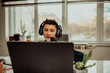 © Minet - little boy using laptop and headphones studying math during his online lesson at home, social distance during quarantine, self-isolation. takes notes. E-Education Distance Home Education.