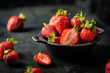 Fresh ripe strawberry in a bowl on dark background