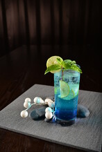 Iced Blue Island Cooler Soda Mocktail With Lime And Mint Leaf Kombucha In Glass On Bar Counter Dark Night Background Cold Halal Drink Menu
