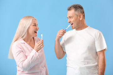 Canvas Print - Mature couple brushing teeth on color background