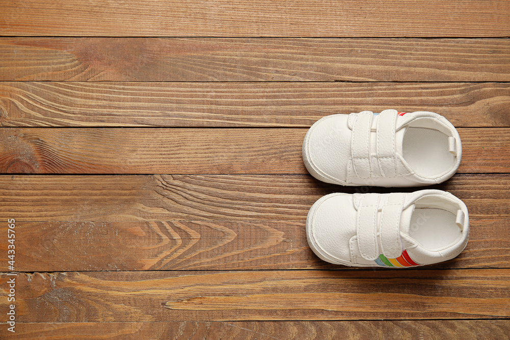 Stylish baby shoes on wooden background