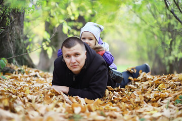 Leaf fall in the park. Children for a walk in the autumn park. Family. Fall. Happiness.