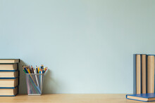 Home Office Desk Table Background. Empty Wall With Wooden Table With Stationery And Books For Work Or Study.