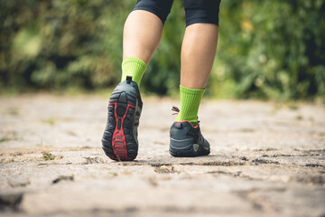 Wall Mural - young fitness woman hiker legs walking at forest trail