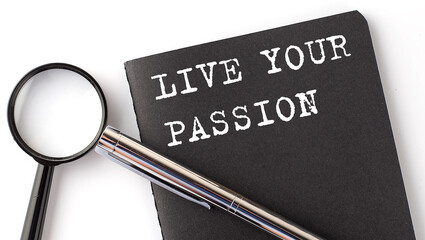 Poster - LIVE YOUR PASSION - business concept, magnifier with white text message on black notebook