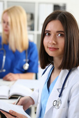 Wall Mural - Beautiful smiling female doctor hold clipboard pad